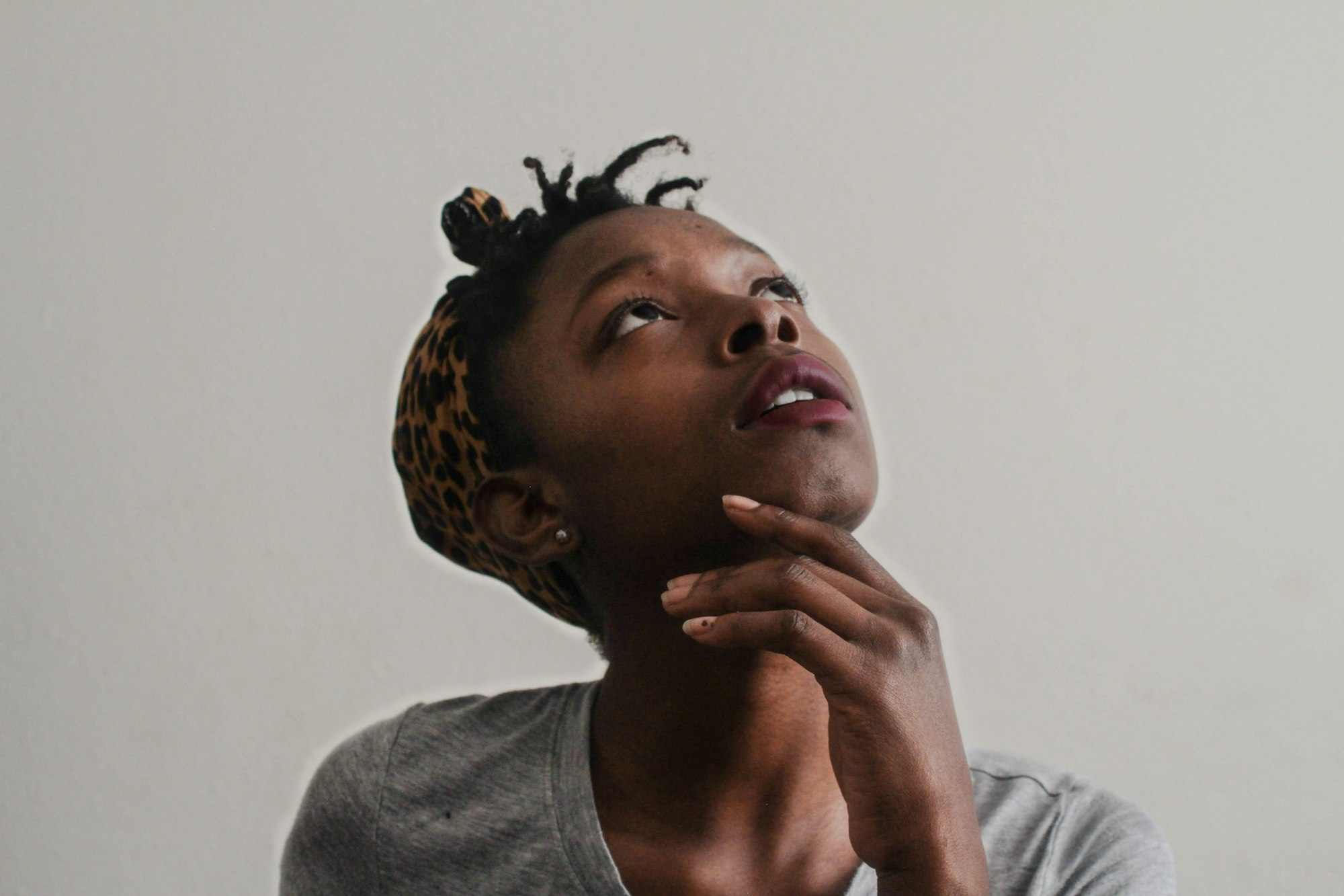 woman considering looking up in thought as if feeling unsure confused afraid or guilty